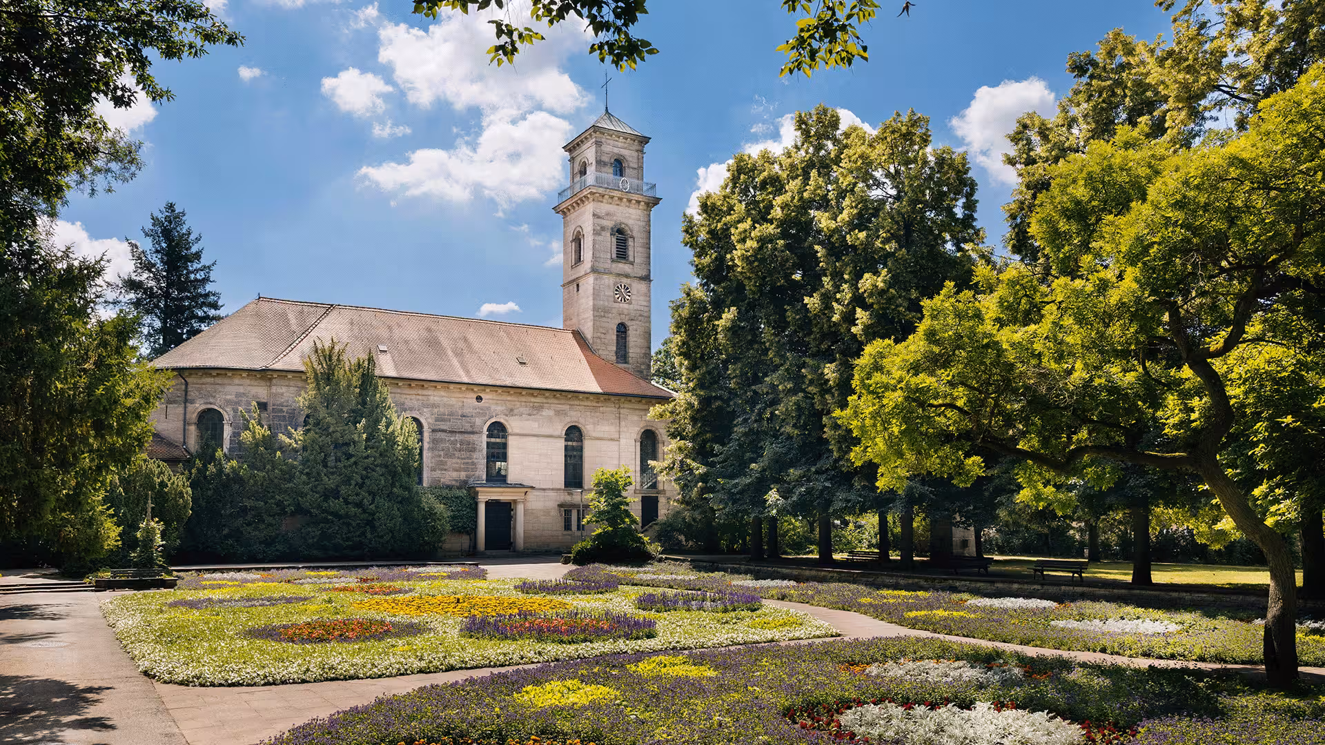 Kirchturm in Fürth, umgeben von Bäumen